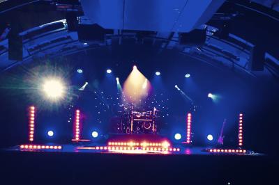 Un groupe de musiciens et une chanteuse se produisent sur scène sous des lumières colorées.