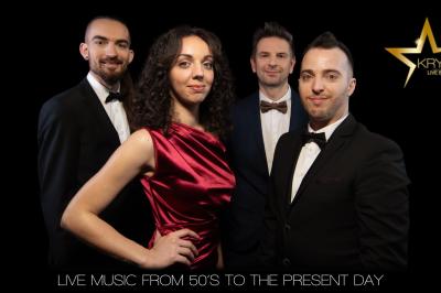 Un groupe de musiciens et une chanteuse se produisent sur scène sous des lumières colorées.