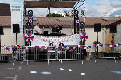 Miniature DJ L'Haÿ-les-Roses (Val-de-Marne) - Showtail Light #14 Cube lumineux coloré disposé sur une terrasse en soirée, près d'une tente blanche et d'une table dressée.