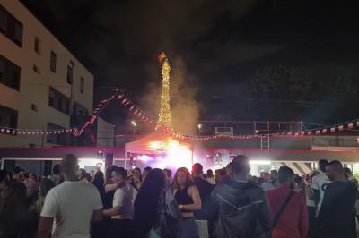 Miniature DJ L'Haÿ-les-Roses (Val-de-Marne) - Showtail Light #13 Cube lumineux coloré disposé sur une terrasse en soirée, près d'une tente blanche et d'une table dressée.