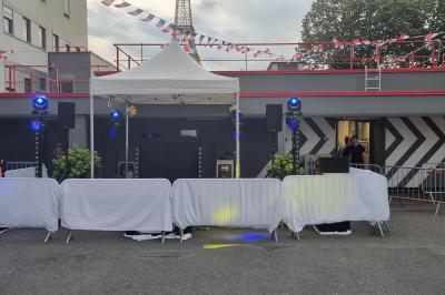 Miniature DJ L'Haÿ-les-Roses (Val-de-Marne) - Showtail Light #17 Cube lumineux coloré disposé sur une terrasse en soirée, près d'une tente blanche et d'une table dressée.