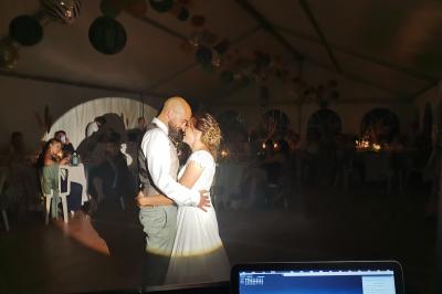 Table décorée avec des bougies allumées en premier plan, devant une fontaine éclairée et une réception en soirée.