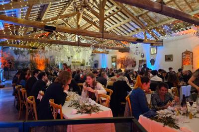 Table décorée avec des bougies allumées en premier plan, devant une fontaine éclairée et une réception en soirée.