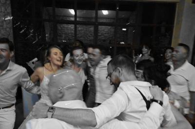 Table décorée avec des bougies allumées en premier plan, devant une fontaine éclairée et une réception en soirée.