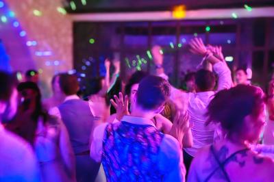 Table décorée avec des bougies allumées en premier plan, devant une fontaine éclairée et une réception en soirée.