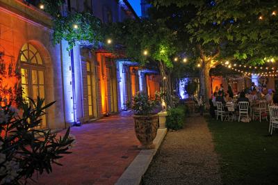 Table décorée avec des bougies allumées en premier plan, devant une fontaine éclairée et une réception en soirée.