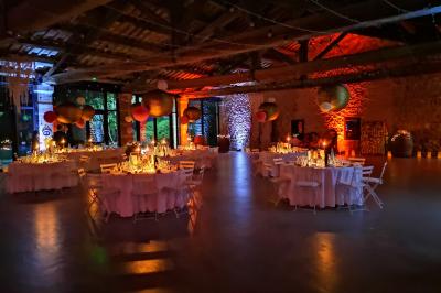 Table décorée avec des bougies allumées en premier plan, devant une fontaine éclairée et une réception en soirée.