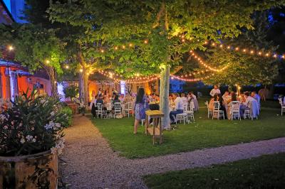 Table décorée avec des bougies allumées en premier plan, devant une fontaine éclairée et une réception en soirée.