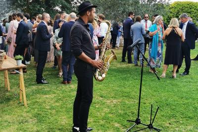 Table décorée avec des bougies allumées en premier plan, devant une fontaine éclairée et une réception en soirée.