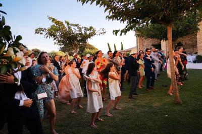 Table décorée avec des bougies allumées en premier plan, devant une fontaine éclairée et une réception en soirée.