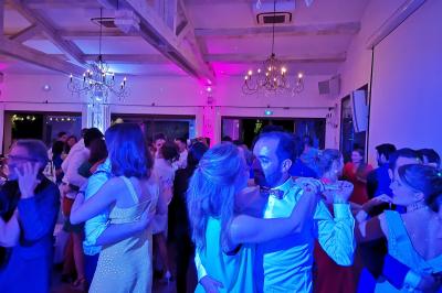 Table décorée avec des bougies allumées en premier plan, devant une fontaine éclairée et une réception en soirée.