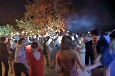 Table décorée avec des bougies allumées en premier plan, devant une fontaine éclairée et une réception en soirée.