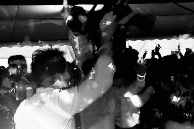 Table décorée avec des bougies allumées en premier plan, devant une fontaine éclairée et une réception en soirée.