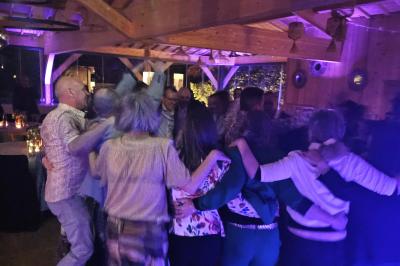 Table décorée avec des bougies allumées en premier plan, devant une fontaine éclairée et une réception en soirée.