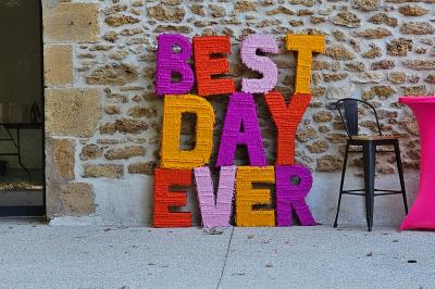 Table décorée avec des bougies allumées en premier plan, devant une fontaine éclairée et une réception en soirée.