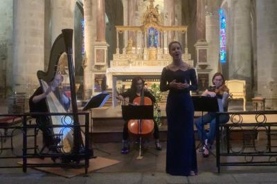 Miniature Concert Une violoncelliste joue lors d'une cérémonie dans une église, entourée d'invités debout et de mariés à l'arrière-plan.