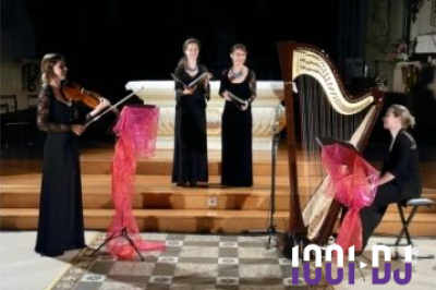 Miniature Concert Une violoncelliste joue lors d'une cérémonie dans une église, entourée d'invités debout et de mariés à l'arrière-plan.