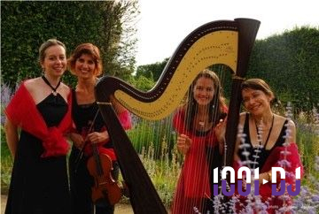 Miniature Ensemble Althéa Une violoncelliste joue lors d'une cérémonie dans une église, entourée d'invités debout et de mariés à l'arrière-plan.