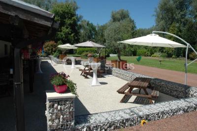 Miniature Location salle Mortagne-du-Nord (Nord) - L'escarpolette #2 Vue d'un étang entouré d'arbres et de végétation sous un ciel partiellement nuageux.