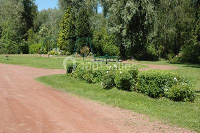 Miniature Location salle Mortagne-du-Nord (Nord) - L'escarpolette #16 Vue d'un étang entouré d'arbres et de végétation sous un ciel partiellement nuageux.