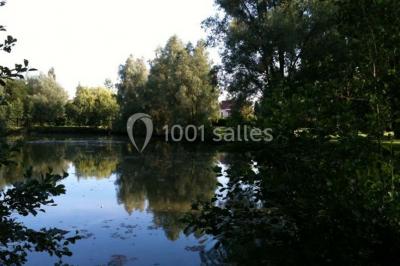 Miniature Location salle Mortagne-du-Nord (Nord) - L'escarpolette #19 Vue d'un étang entouré d'arbres et de végétation sous un ciel partiellement nuageux.