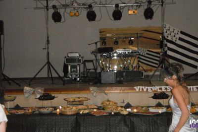 Buffet garni de plats variés devant une scène équipée de matériel de sonorisation et éclairée par des projecteurs.