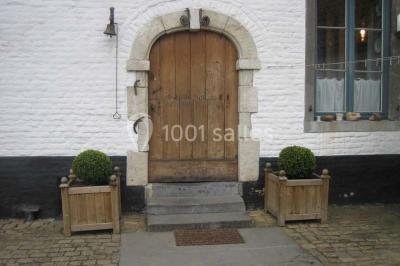 Miniature Location salle Court-Saint-Étienne (Brabant wallon) - Ferme de Beaurieux #4 Charpente en bois apparente d'un bâtiment ancien avec des murs en briques et un éclairage intérieur chaleureux.