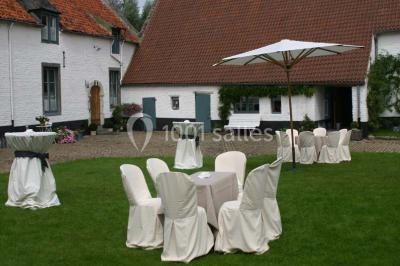 Miniature Location salle Court-Saint-Étienne (Brabant wallon) - Ferme de Beaurieux #9 Charpente en bois apparente d'un bâtiment ancien avec des murs en briques et un éclairage intérieur chaleureux.