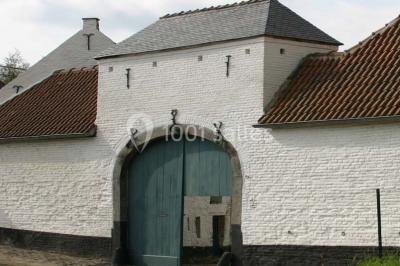 Miniature Location salle Court-Saint-Étienne (Brabant wallon) - Ferme de Beaurieux #13 Charpente en bois apparente d'un bâtiment ancien avec des murs en briques et un éclairage intérieur chaleureux.