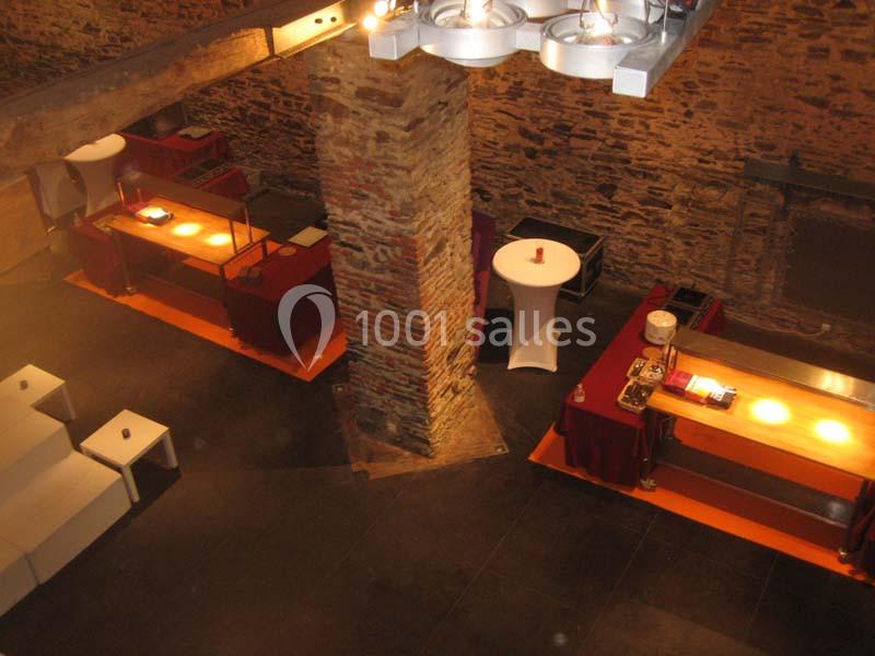 Location salle Court-Saint-Étienne (Brabant wallon) - Ferme de Beaurieux #14 Salle en pierre avec poutres apparentes, tables éclairées pour buffet et mobilier de réception.