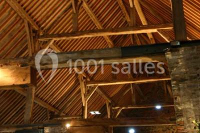 Miniature Location salle Court-Saint-Étienne (Brabant wallon) - Ferme de Beaurieux #20 Charpente en bois apparente d'un bâtiment ancien avec des murs en briques et un éclairage intérieur chaleureux.