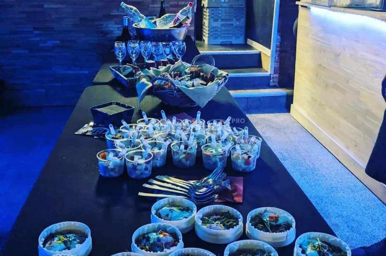 Table de buffet avec verrines, paniers de pain, couverts et verres à vin, dans une ambiance lumineuse tamisée.