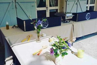 Miniature Traiteur Laloeuf (Meurthe-et-Moselle) - L'art Home des Saveurs #22 Tables dressées avec nappes beiges, décorées de bouquets de fleurs et d'ustensiles en bois, devant des volets bleus.