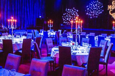 Miniature Animson #4 Portraits scintillants de deux figures célèbres réalisés en paillettes sur des panneaux noirs, exposés sur une scène.