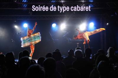 Miniature Animson #16 Portraits scintillants de deux figures célèbres réalisés en paillettes sur des panneaux noirs, exposés sur une scène.