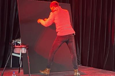 Miniature Animson #18 Portraits scintillants de deux figures célèbres réalisés en paillettes sur des panneaux noirs, exposés sur une scène.