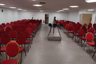 Miniature Location salle Fontenay-sous-Bois (Val-de-Marne) - Salon Ciel de France #9 Rangées de chaises rouges alignées dans une salle vide avec un sol en béton et des murs blancs.