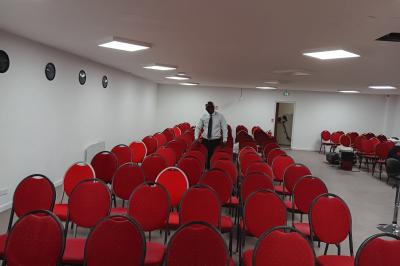 Miniature Location salle Fontenay-sous-Bois (Val-de-Marne) - Salon Ciel de France #8 Rangées de chaises rouges alignées dans une salle vide avec un sol en béton et des murs blancs.