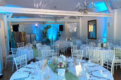 Homme concentré cuisinant en extérieur sur une plancha, entouré de végétation sous un ciel nuageux.