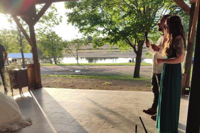 Un DJ mixe dans une salle éclairée par des lumières colorées, avec des tables hautes et un décor sobre.