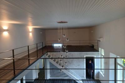 Salle lumineuse avec une grande table dressée pour un repas, décorée de fleurs blanches et rouges, entourée de chaises…