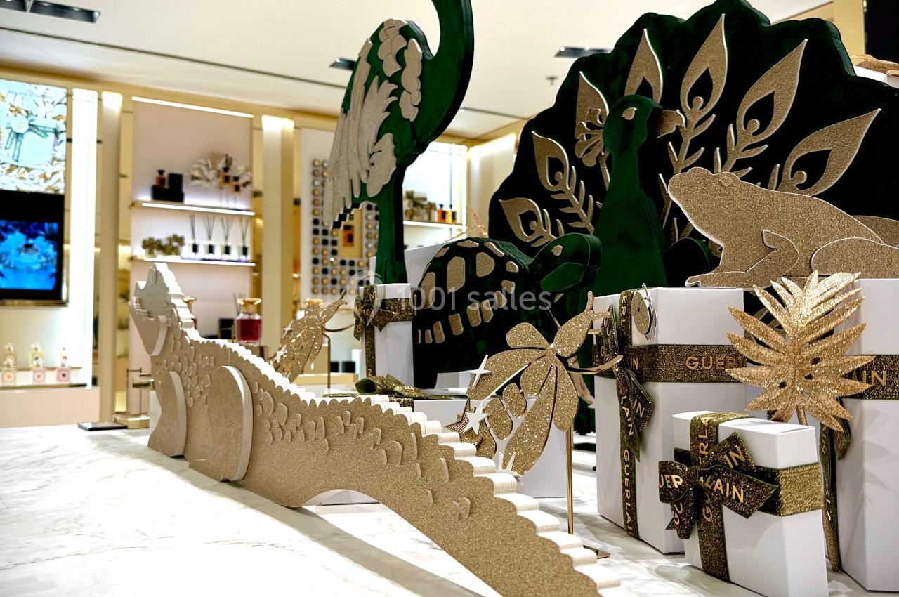 Décorations dorées et vertes en forme d'animaux exotiques sur un comptoir en marbre dans un espace lumineux.