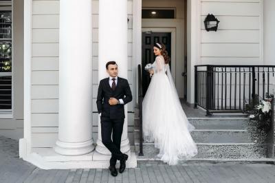 Miniature Votristoire #9 Table en bois longue dressée en extérieur, ornée de fleurs, citrons et vaisselle, entourée d'arbres et de verdure.