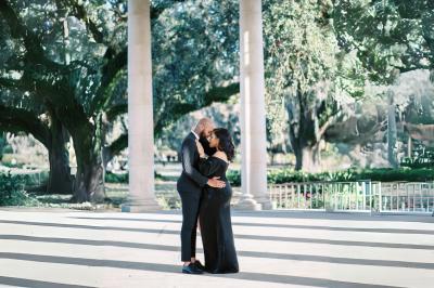 Miniature Votristoire #15 Table en bois longue dressée en extérieur, ornée de fleurs, citrons et vaisselle, entourée d'arbres et de verdure.
