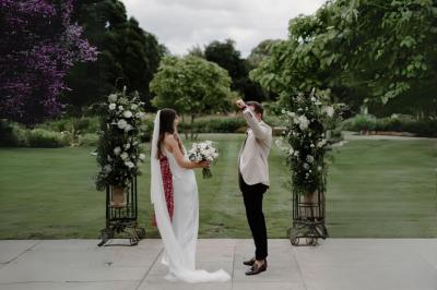 Miniature Votristoire #19 Table en bois longue dressée en extérieur, ornée de fleurs, citrons et vaisselle, entourée d'arbres et de verdure.