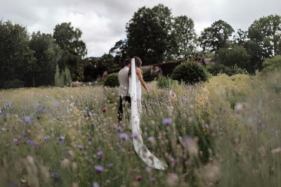 Miniature Votristoire #20 Table en bois longue dressée en extérieur, ornée de fleurs, citrons et vaisselle, entourée d'arbres et de verdure.