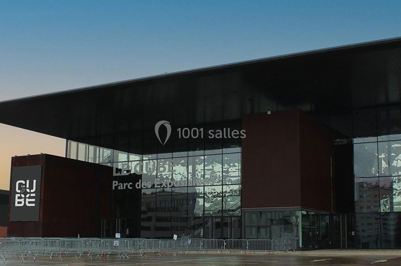 Façade moderne du bâtiment ’Le Cube’ au Parc des Expositions, avec des barrières installées à l'entrée.