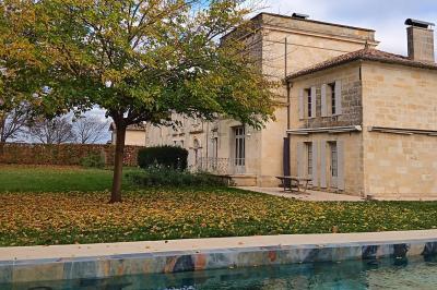 Vue d'un jardin verdoyant avec un arbre central, un escalier en pierre et un lac au coucher du soleil.