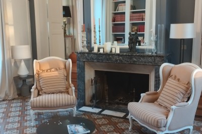 Vue d'un jardin verdoyant avec un arbre central, un escalier en pierre et un lac au coucher du soleil.