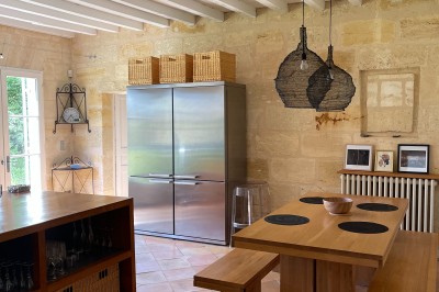 Vue d'un jardin verdoyant avec un arbre central, un escalier en pierre et un lac au coucher du soleil.